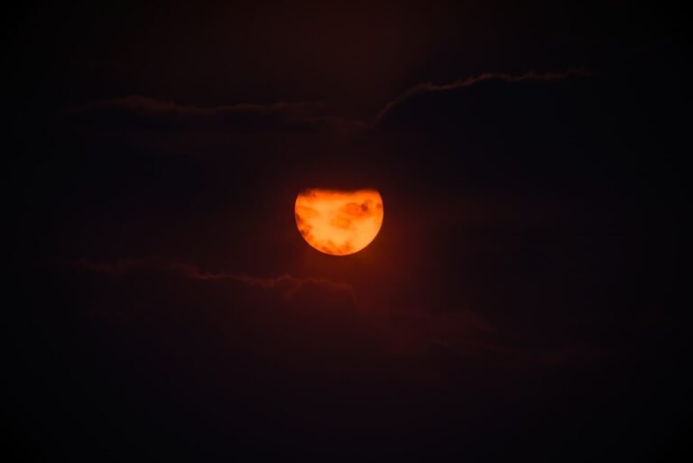 Puesta de sol ardiente con nubes oscuras rodeando el sol en un cielo profundamente contrastado. Fotografía de Ignacio Arcas Almudí